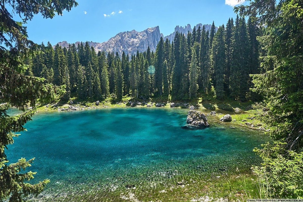 Il lago di Carezza e sullo sfondo il Rosengarten Catinaccio Lago di Carezza in primavera